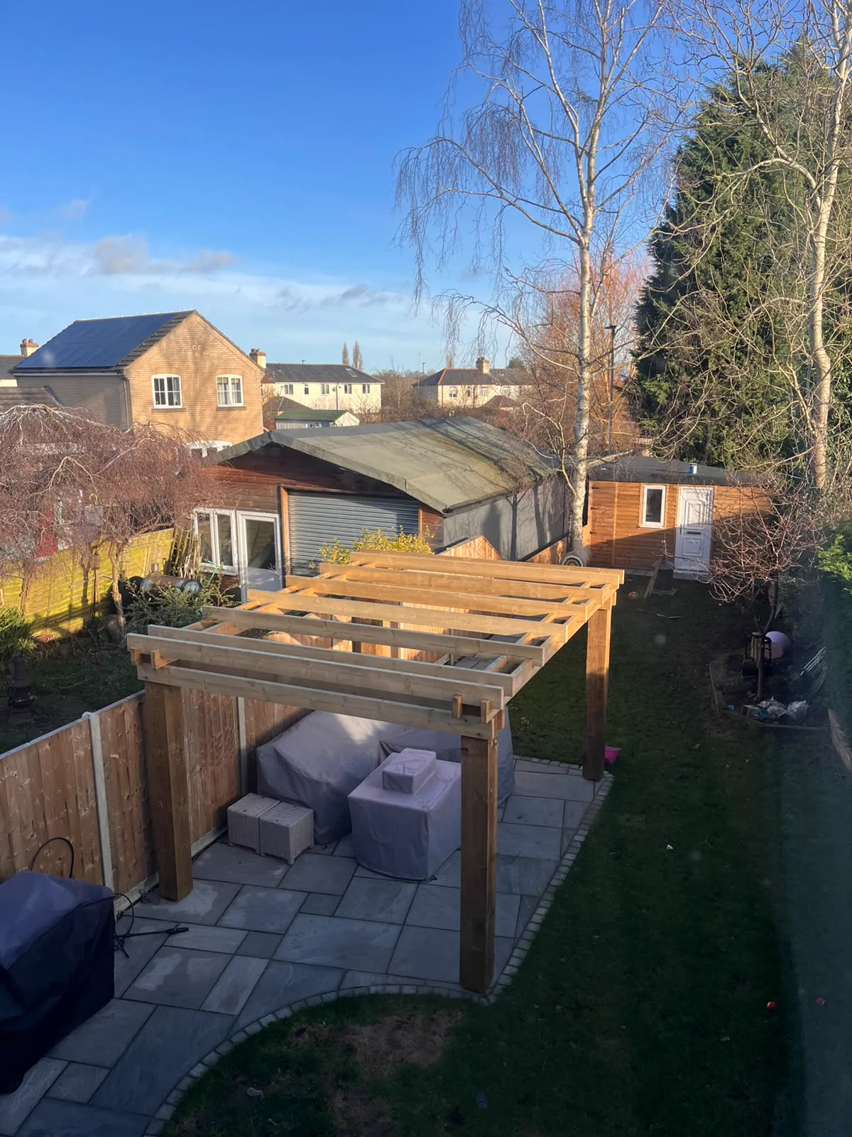 Timber pergola over a paved garden seating area